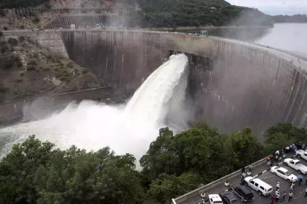 In this file 2008 photo, people watch as the spillway gates are opened at Kariba North Bank dam on Lake Kariba to reduce rising water levels as a measure to protect the dam. Photo: Mackson Wasamunu, Reuters