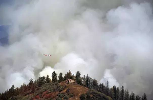 A United States Forest Service Cobra helicopter flies over the burn-out operation along McKenzie Ridge Saturday, September 19, 2015 near Kings Canyon National Park, Calif. ERIC PAUL ZAMORA 