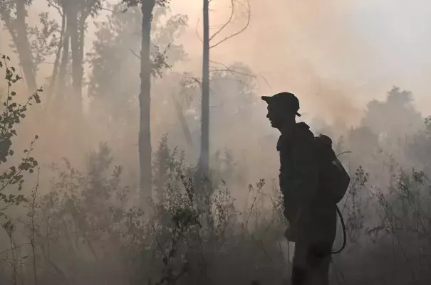 A specialist of Russian Federal Agency for Forestry works to put out a forest fire outside the village of Basly in Omsk Region, Russia August 11, 2020. (Credit: REUTERS/Alexey Malgavko)