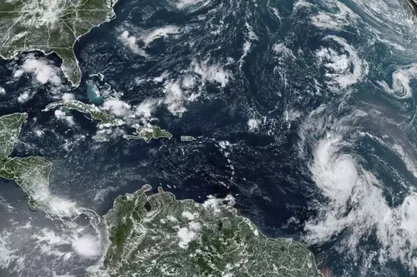 This Wednesday, Sept. 6, 2023, satellite image provided by the National Oceanic and Atmospheric Administration shows Hurricane Lee, right, off in the central tropical Atlantic Ocean. (Credit: NOAA via AP)