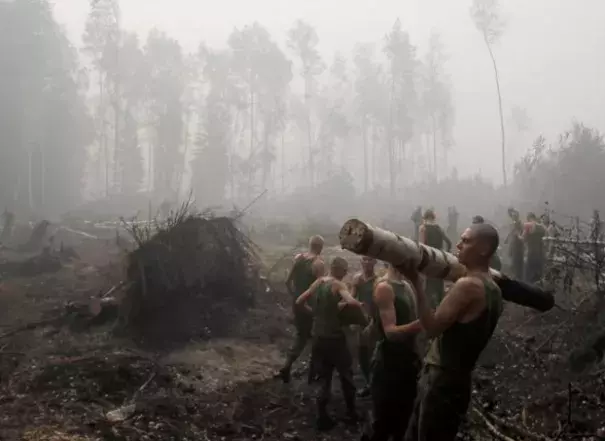 Russian service members haul away trees felled to hold wildfires at bay outside the town of Lukhovitsy on August 6. Photo: Denis Sinyakov, Reuters