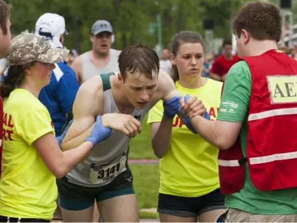 Terence Hughes, from Hanover, New Hampshire, is helped by the medical staff after collapsing at the finish line during the People's United Bank Vermont City Marathon on Sunday morning. Photo: Brian Jenkins, Free Press