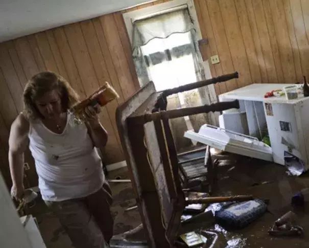 Theresa Havers helps clean out the kitchen of her son's home after flooding in Rainelle, W.Va., on June 26, 2016. Photo: Christian Tyler Randolph, Charleston Gazette-Mail, via AP