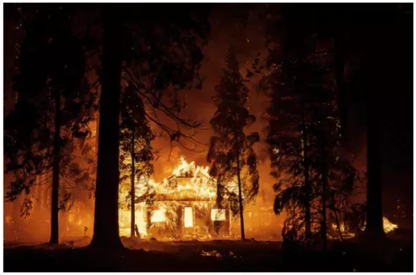 A home burns as flames from the Dixie fire tear through the Indian Falls neighborhood of unincorporated Plumas County, Calif., in July. The massive fire churned across nearly 1 million acres. (Josh Edelson/AFP/Getty Images)