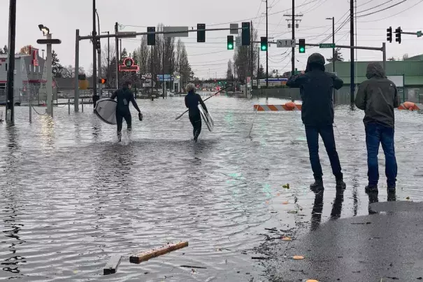 Caylon Coomes left, and another man prepare to paddleboard in floodwaters on city streets in Bellingham, Wash., Monday. (Lisa Baumann/AP)