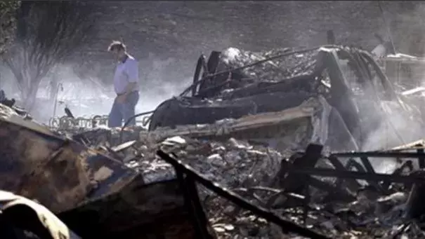 Vern Smith walks through the rubble of his still smoldering home on June 29, 2015, one of some two dozen destroyed in a wildfire the night before, in Wenatchee, Wash. Photo: Elaine Thompson, AP