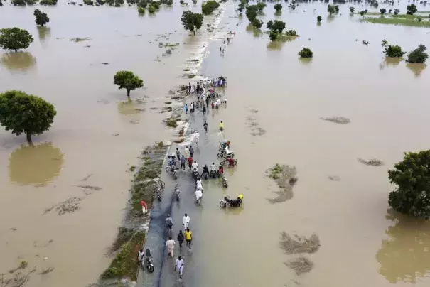 FILE - People walk through floodwaters after heavy rainfall in Hadeja, Nigeria, Sept 19, 2022. Looking back at 2022’s weather with months of analysis, the World Meteorological Organization says last year really was as bad as it seemed. (AP Photo, File)