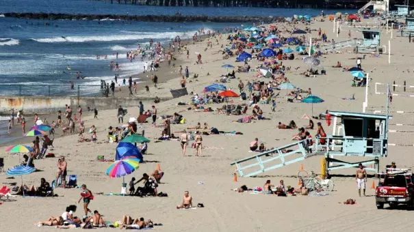 In this Feb. 15, 2016, file photo swimmers and sunbathers gather at Redondo Beach, Calif. El Nino has so far left much of drought-stricken California in the dust, delivering a few quick storms but not yet bringing the legendary rain previously linked to the periodic ocean-warming phenomenon. Image: John Antczak, AP Photo