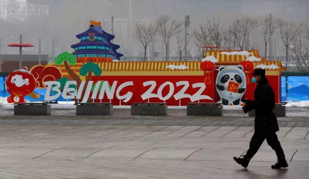 A security guard walks past advertising boards outside the Main Press Centre ahead of the Beijing 2022 Winter Olympics in Beijing, China, January 24, 2022. (Credit: REUTERS/Fabrizio Bensch)