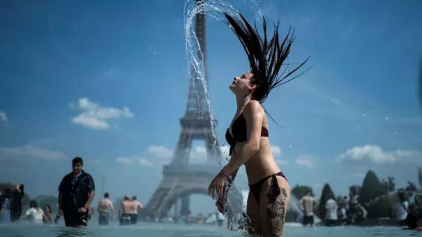 A woman wades in a fountain at Paris' Trocadero esplanade in an attempt to keep cool amid 100-degree weather in the French capital. Photo: KENZO TRIBOUILLARD, AFP/Getty Images