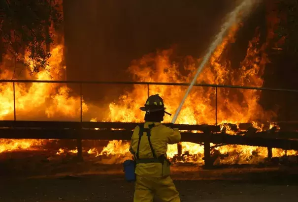 A firefighter sprays a hose into a Keysight Technologies building in Santa Rosa last month during the wildfires that killed 42 people and destroyed 8,700 homes and buildings. Photo: Jeff Chiu, Associated Press Photo