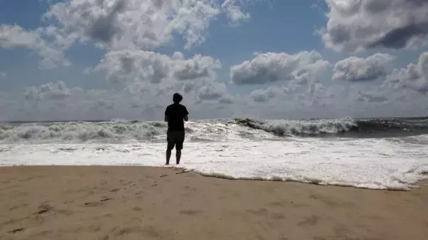 A beachgoer stands at the edge of the water, Sunday, Sept. 4, 2016, in Bridgehampton, New York, on the southeastern shore of Long Island, where the effects of storm system Hermine could be seen in the rough surf and a ban on swimming. Photo: Jennifer Peltz, AP