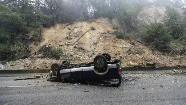 An overturned vehicle blocks a south bound lane next to a mudslide on Highway 17, Tuesday, February 7, 2017. Photo: Marcio Jose Sanchez, AP