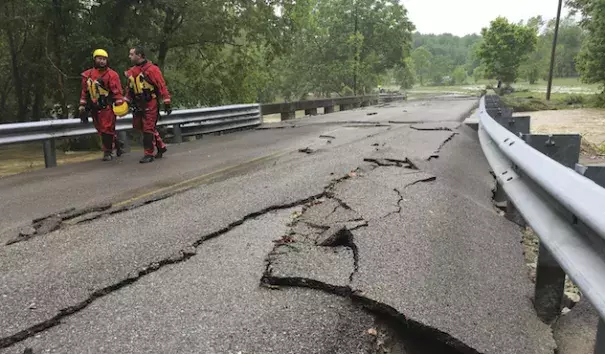 Rescuer workers walk down a road damaged by flash flooding, Friday, May 19, 2017, in Sumner County, Tenn. Overnight storms brought several inches of rain, causing several creeks to rise. Photo: Lacy Atkins/The Tennessean via AP