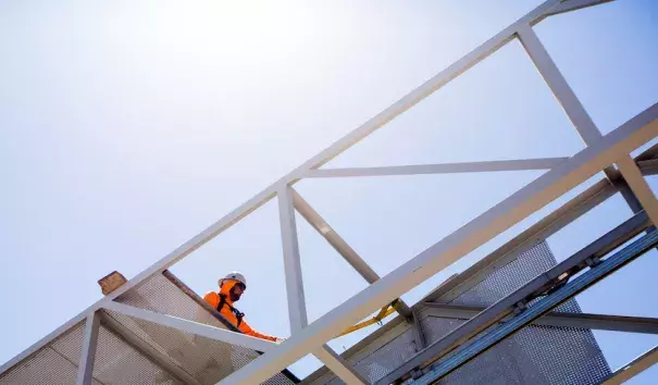 Construction worker Ricardo Castro works under the summer sun as he adds a panel to an overhead sign in Phoenix, Ariz., June 15, 2017. He said his bright orange hoodie helps keep him cool by trapping his sweat, which counters the dry heat. Castro will work through next week, when temperatures in the Phoenix area are expected to reach or exceed 120°F. Photo: Angie Wang, AP