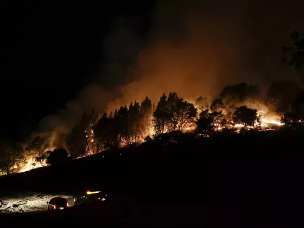 Firefighters watch from their fire trucks as wildfires continue to burn on Thursday, near Calistoga, Calif. Jae C. Hong/AP