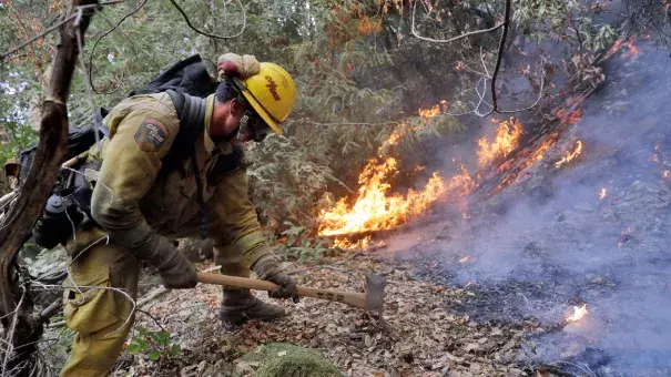 A firefighter builds a containment line as he battles a wildfire Tuesday, Oct. 17, 2017, near Boulder Creek, California. Photo: Marcio Jose Sanchez, AP