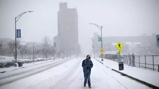 A pedestrian walks down the middle of Washington Street, Wednesday, Jan. 17, 2018, in Greensboro, N.C. The National Weather Service has issued a winter storm warning for Greensboro with a snow accumulation between 4-7 inches expected. Photo: Andrew Krech, News & Record via AP