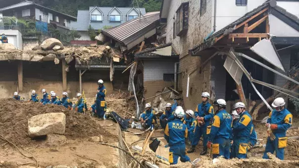 Emergency teams rest outside of structural damage caused by heavy rains, Monday, July 9, 2018, in Hiroshima, Japan. Credit: Haruka Nuga, AP