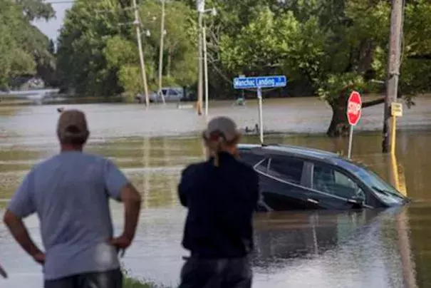 In this Aug. 16, 2016 file photo, residents survey the flood water on Old Jefferson Highway at Bayou Manchac in Prairieville, La. The flooding killed at least 13 people, damaged 150,000 homes and cost at least $8.7 billion. Photo: Max Becherer, AP