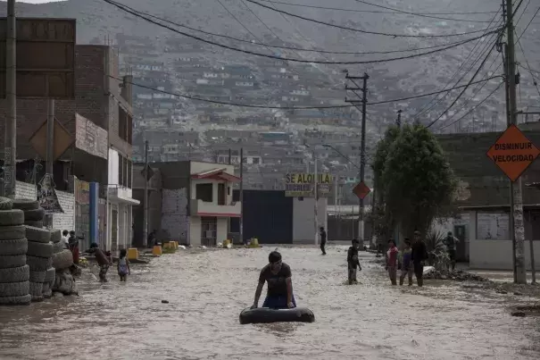 A man plays in a flooded street using an inner tube in Lima, Peru, Thursday, March 16, 2017. A new round of unusually heavy rains has killed at least a dozen people in Peru and now threatens flooding in the capital. Authorities said Thursday they expect the intense rains caused by the warming of surface waters in the eastern Pacific Ocean to continue another two weeks. Photo: Rodrigo Abd, Associated Press