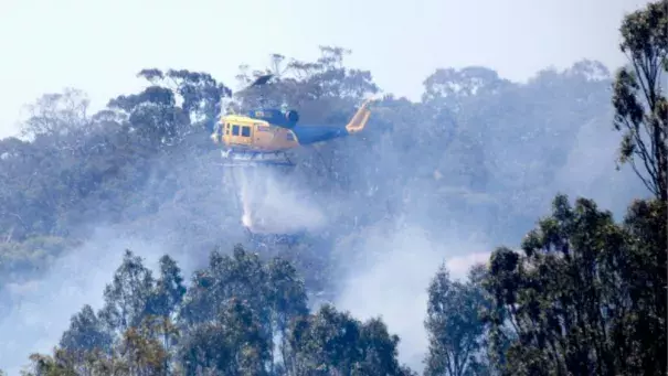 A helicopter helps the effort to control a fire in Sunbury on Christmas Day. Photo: Simon O'Dwyer
