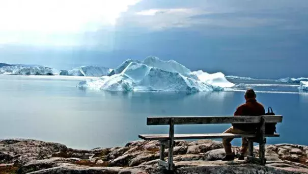 An old man looks out on a Greenland glacier. (Flickr/Goran Ingman)