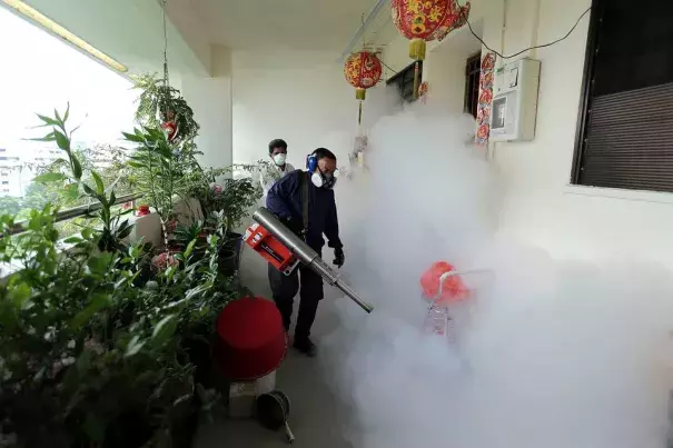 Workers fogged a housing estate in Singapore to kill mosquitos on Sunday. Photo: Agence France-Presse / Getty Images