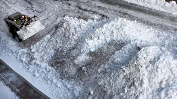 A Bobcat adds to a growing snow pile on Monument Street as it is removed from the 700 block of Calvert Street on Monday morning following the weekend snowstorm. Photo: Jerry Jackson, Baltimore Sun)