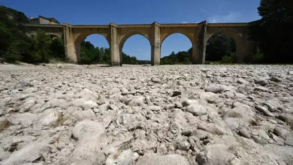 (FILES) A photograph shows the parched river bed of the Gardon near the Saint-Nicolas de Campagnac bridge in Saint-Anastasie, southern France, after a heat wave hit in June 2022 (Credit: Pascal GUYOT / AFP/File)