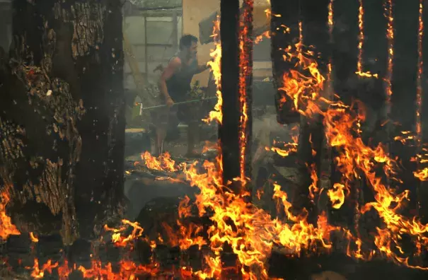 A resident tried to save his home in Glen Ellen, California, as the powerful winds blew burning embers. The hot summer created conditions ripe for fueling wildfires. Photo: Justin Sullivan, Getty Images