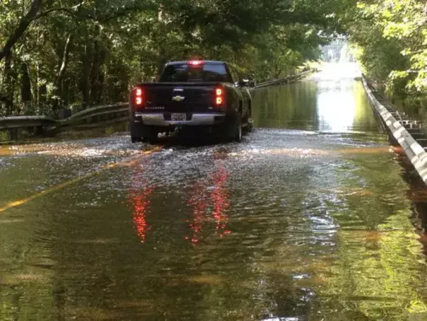  A truck goes through a flooded road. Photo: Venton Blantin