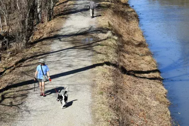 In shorts and a T-shirt, Sara Walters and her dog, Rolo, walk along the C&O Canal towpath on Wednesday. Photo: Katherine Frey, The Washington Post