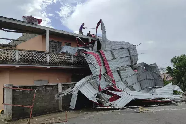 People work on a damaged building, in Mananjary district, Madagascar, Wednesday Feb. 22, 2023 after cyclone Freddy reached Madagascar. A slightly weakened Cyclone Freddy has made landfall in Madagascar, where schools, businesses and public transportation were shut down ahead of its arrival. Freddy was packing winds gusting to 180 kilometers per hour, or about 111 miles per hour, as it came ashore in a nation already hit in January by a tropical storm that killed at least 30 people. (Credit: AP Photo/Solofo 