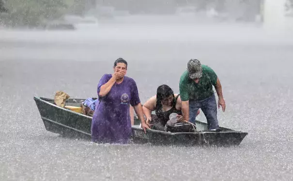 Dee Vazquez, from left, helps Georgette Centelo and her grandfather Lawrence Roberts after they tried to recover their belongings from a family mobile home in Central, north of Baton Rouge, La., Monday, Aug. 15, 2016. Photo: David Grunfeld / The Times-Picayune via AP