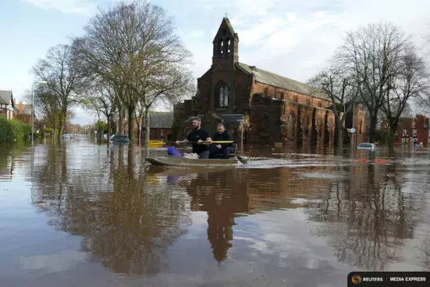 Local residents canoe through flood water as they help to rescue people on a residential street in Carlisle, Britain on Dec. 6, 2015. Photo: REUTERS/Phil Noble