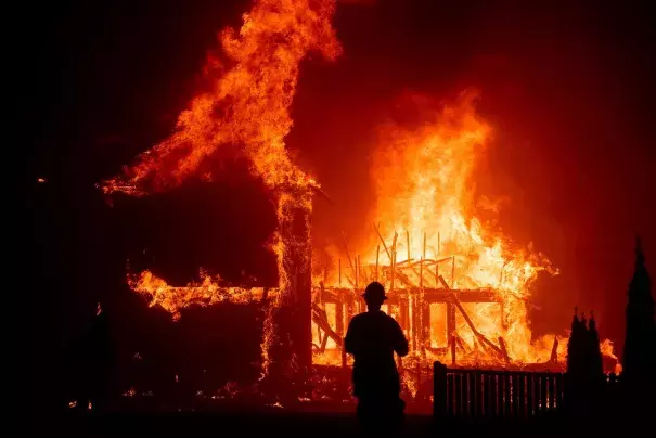 A home burns as the Camp Fire rages through Paradise, Calif., in November 2018. Credit: Noah Berger, Associated Press