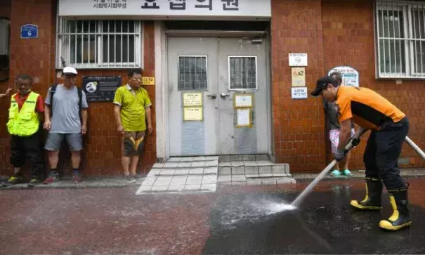 A firefighter sprays water in an alley of a residential district in Seoul to help ease the summer heat. Photo: Jung Yeon-Je, AFP/Getty Images