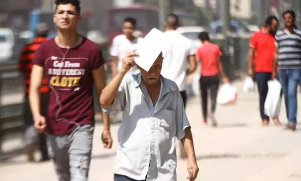 FILE - An Egyptian man covers his head with a paper to avoid the sun rays amid high temperature in Cairo- the photo was taken on August 3, 2018. Photo: Mohamed Fawzy, Egypt Today
