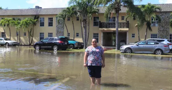 Karina Castillo, an activist for the group Mom's Clean Air Force, standing in tidal flooding in Shorecrest, Miami. Photo: Dayna Reggero for Clean Air Moms Action