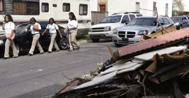 Students walk next to a pile of debris. Students walk past a debris pile from a house damaged during Hurricane Katrina. Photo: Lee Celano, Reuters