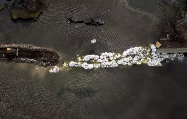 A helicopter tries to repair a breached New Orleans levee that was damaged by Katrina. Photo: Gabooza