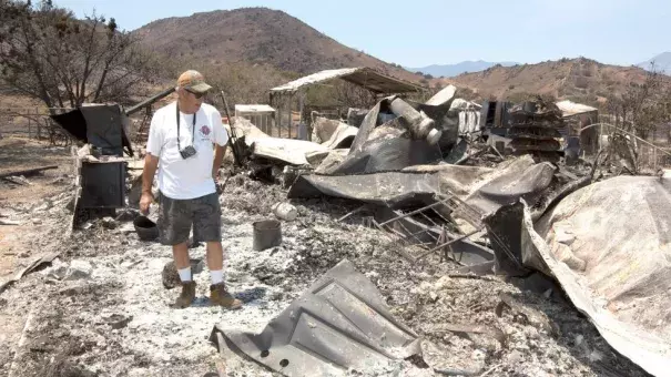 Steve Keeling walks through the ashes of his fire ravaged home, Monday, June 27, 2016, in South Lake. California. Photo: Rich Pedroncelli, AP