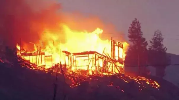 Flames from the Erskine fire tear through a house in the Lake Isabella area. Photo: KBAK via CNN