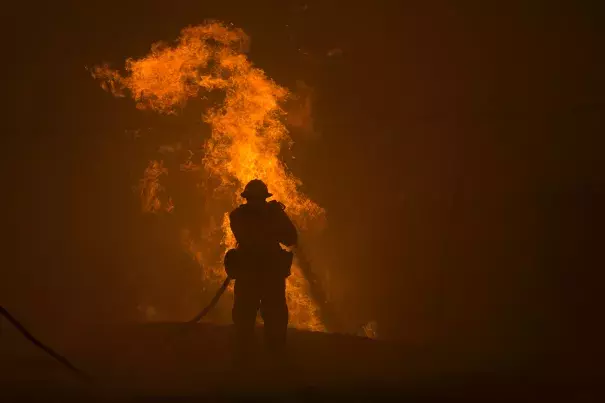 A firefighter hosed down burning pipes on Saturday near Santa Clarita, Calif. Photo: David McNew / Agence France-Presse — Getty Images