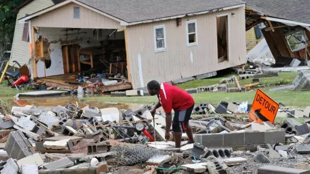 A White Sulphur Springs resident sorts through debris as the cleanup begins from severe flooding in White Sulphur Springs, West Virginia. Photo: Steve Helber, AP