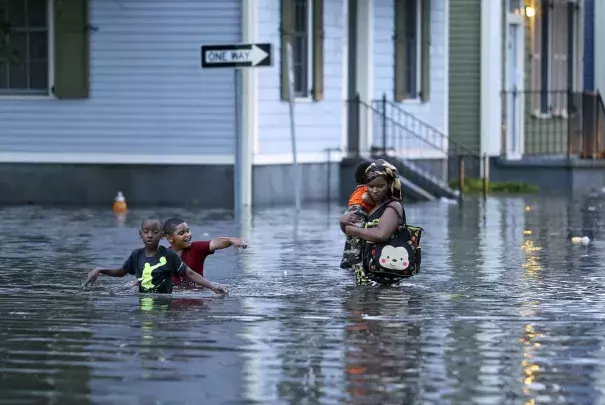 This Saturday, Aug. 5, 2017 photo shows a woman carrying an infant through floodwaters as two boys tag along in Metairie, La. Photo: Michael DeMocker, NOLA.com/The Times-Picayune via AP