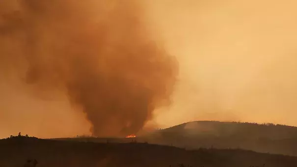 Resident Moe Blythe watches the Holy Fire burn near homes on August 9, 2018 in Corona, California. Photo: Mario Tama, Getty Images