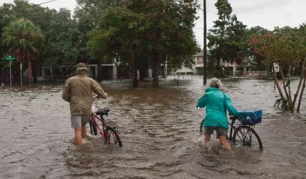 A couple walks their bikes through a flooded street in Mandeville, Louisiana, north of New Orleans, on Sunday, July 14, 2019, after Tropical Storm Barry came ashore. Credit: Seth Herald, AFP, Getty Images