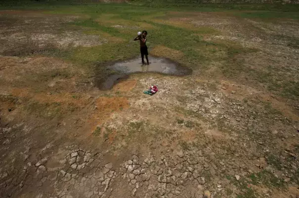 A village boy baths in the remaining water of a dried pond to beat the heat in the outskirts of the eastern Indian city of Bhubaneswar on April 23, 2016. Photo: Getty Images